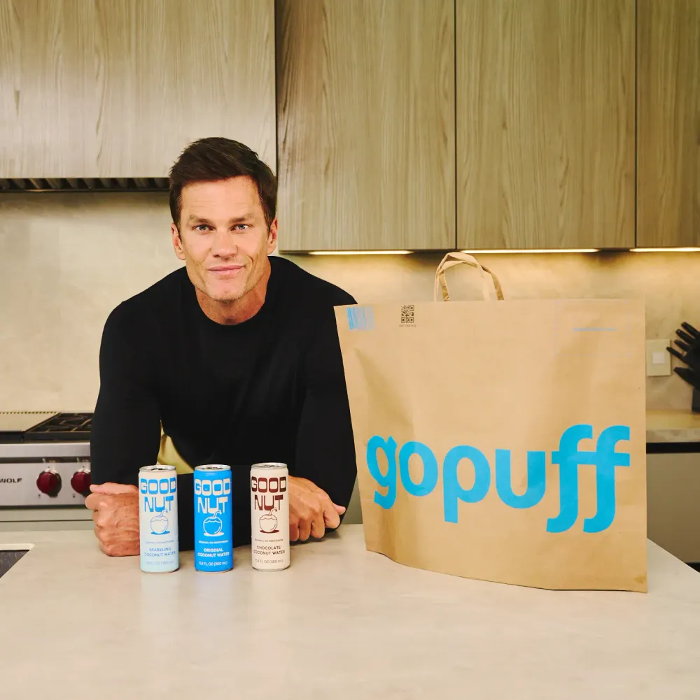 Tom Brady holding Good Nut Coconut Water cans