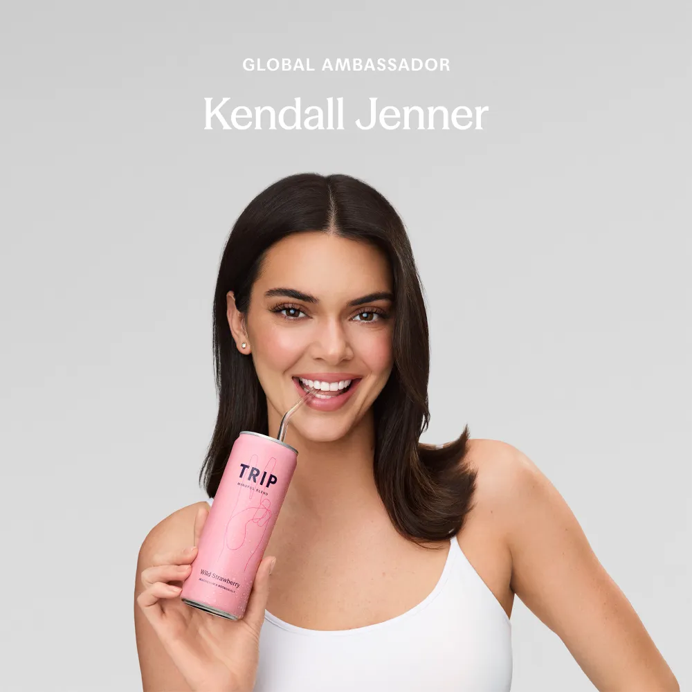 Kendall Jenner, TRIP's Global Ambassador, holding a pink can of TRIP Mindful Blend with a straw