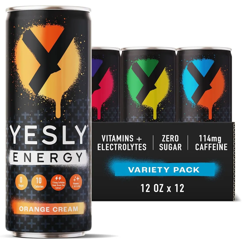 A Yesly Energy variety pack displays several black cans with colorful splatter-style graphics, including a prominent Orange Cream can in front